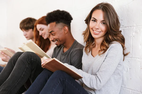 読書室内白壁背景に座っている若い友人学生のイメージ 陽気な女性に焦点を当てる — ストック写真
