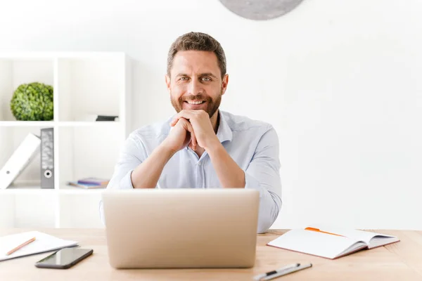 Foto Hombre Barbudo Feliz Sentado Oficina Trabajando Ordenador Portátil —  Fotos de Stock