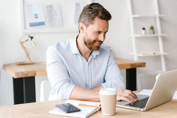 Afbeelding Van Gelukkig Bebaarde Man Zitten Kantoor Werken Laptopcomputer Zoek — Stockfoto