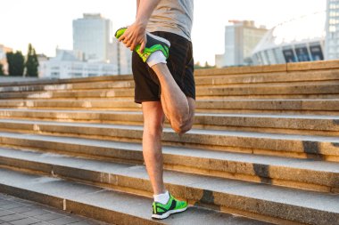 Bacaklar açık havada merdivenlerinde koşu önce uzanan bir sporcu croped görüntü