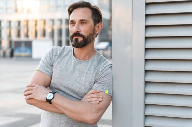 Yakışıklı güçlü olgun sporcu ayakta açık havada bir kenara görünümlü görüntü.