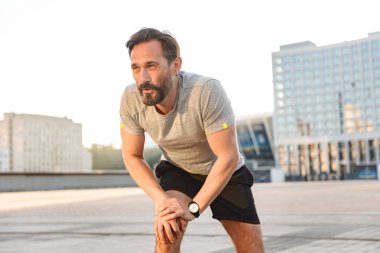 İmge-in yakışıklı konsantre güçlü olgun sporcu spor egzersizleri açık havada yapmak.