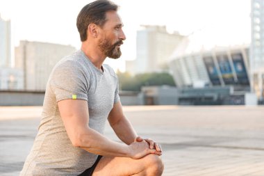 İmge-in yakışıklı konsantre güçlü olgun sporcu spor egzersizleri açık havada yapmak.