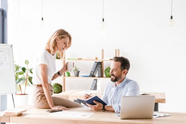 Mutlu meslektaşları süre ofiste oturan ve dizüstü bilgisayarda çalışma çalışma projesi tartışmaya birkaç