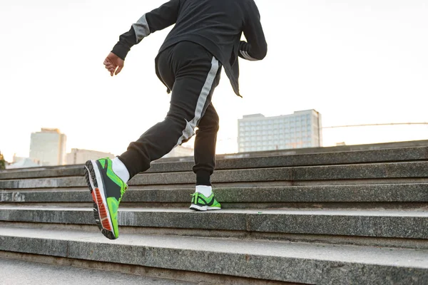 Arkadan görünüşü merdivenlerden yukarı açık havada çalışan bir şık sporcu