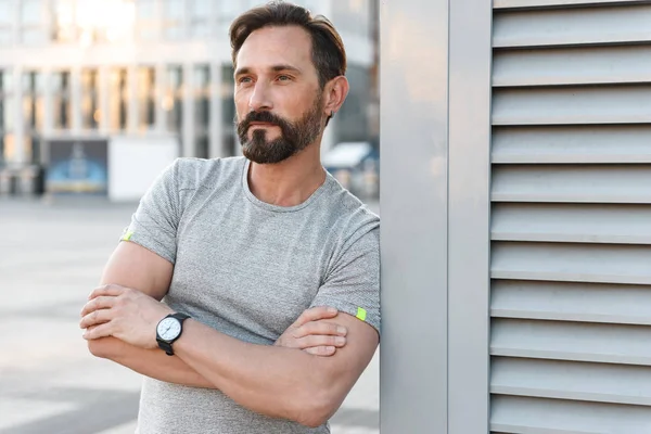 Yakışıklı güçlü olgun sporcu ayakta açık havada bir kenara görünümlü görüntü.