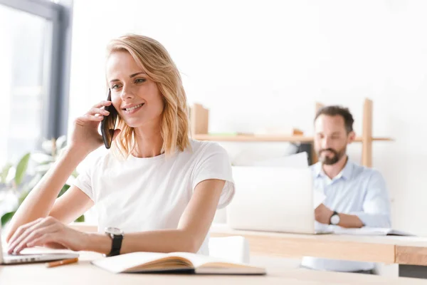 Щаслива Жінка Менеджер Працює Ноутбуком Документами Сидячи Офісі Розмовляючи Мобільному — стокове фото