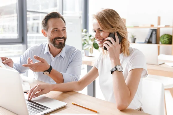 Birlikte laptop ile ofiste otururken bir proje üzerinde çalışıyor meşgul iş arkadaşları birkaç