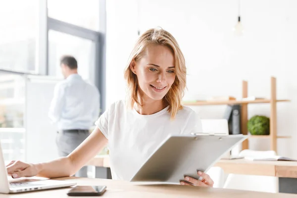 Mulher Sorridente Gerente Trabalhando Computador Portátil Com Documentos Enquanto Sentado — Fotografia de Stock