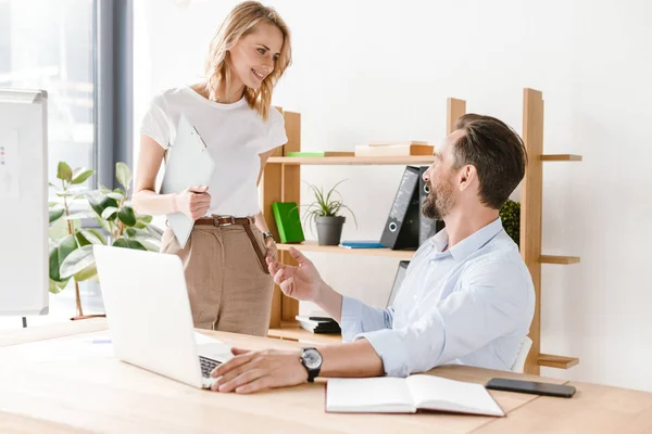 Par Colegas Alegres Discutiendo Proyecto Trabajo Mientras Están Sentados Oficina — Foto de Stock