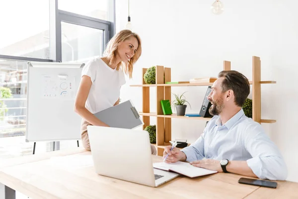 Par Leende Kolleger Som Diskuterer Arbeidsprosjekt Mens Sitter Kontoret Jobber – stockfoto