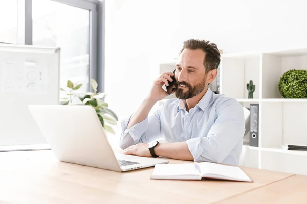 Empresário Confiante Falando Telefone Celular Enquanto Sentado Mesa Escritório Com — Fotografia de Stock