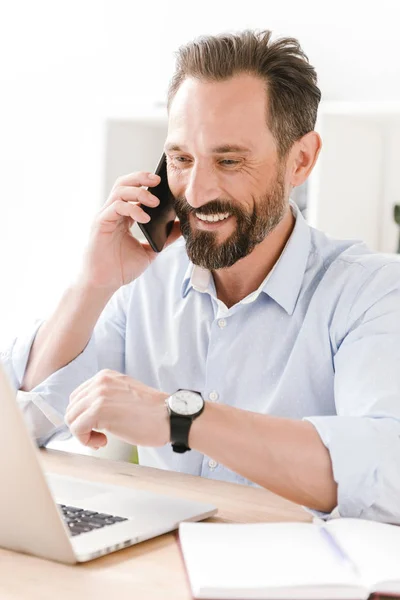 Empresário Feliz Falando Telefone Celular Enquanto Sentado Mesa Escritório Com — Fotografia de Stock