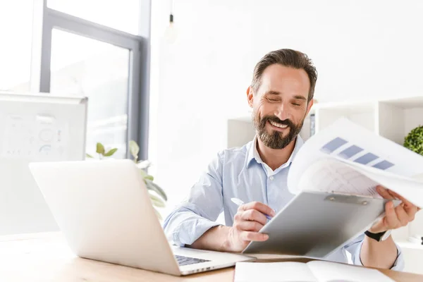 Feliz Hombre Negocios Que Sostiene Carpeta Mientras Está Sentado Escritorio —  Fotos de Stock