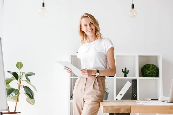 Smiling Businesswoman Holding Folder While Leaning Office Desk — Stock Photo, Image