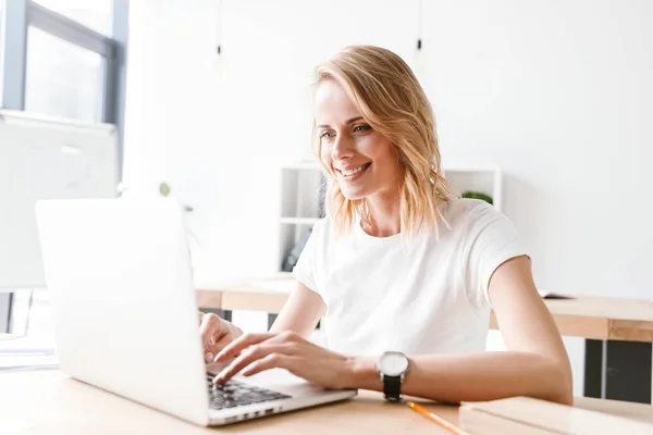 Mulher Negócios Sorrindo Trabalhando Computador Portátil Enquanto Sentado Mesa Escritório — Fotografia de Stock