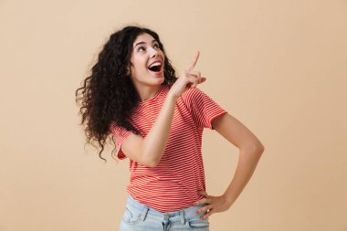 Fotoğraf heyecanlı duygusal genç kadının üzerinde bej duvar arka plan boşaltmak gösterilen izole.