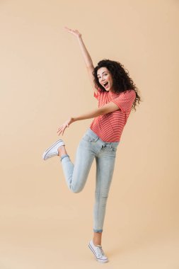 İnanılmaz heyecanlı duygusal genç kadın üzerinde bej duvar arka plan boşaltmak gösterilen izole görüntüsünü.