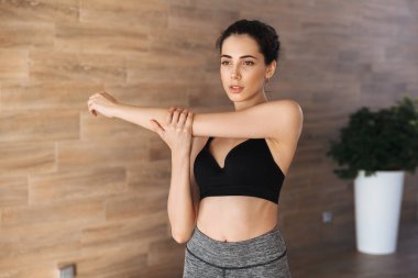 Spor salonunda germe egzersizleri yapıyor konsantre bir genç sporcumuz portresi