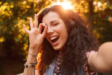 Beyaz kıvırcık kız 18-20 açık ve çekici selfie fotoğraf yürürken ok işareti kameradan bakıyorsun