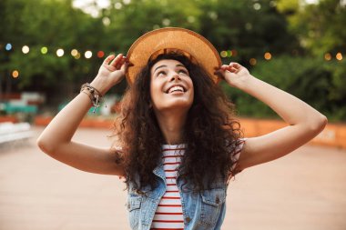 Genç ve güzel esmer kadın 18-20 yaz zevk ve yeşil Park'ta yürüyordunuz hasır şapka giyen fotoğrafı