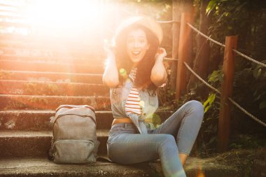 Görüntü hoş sürpriz genç kadının oturan açık havada park adımlar. Görünümlü kamera.