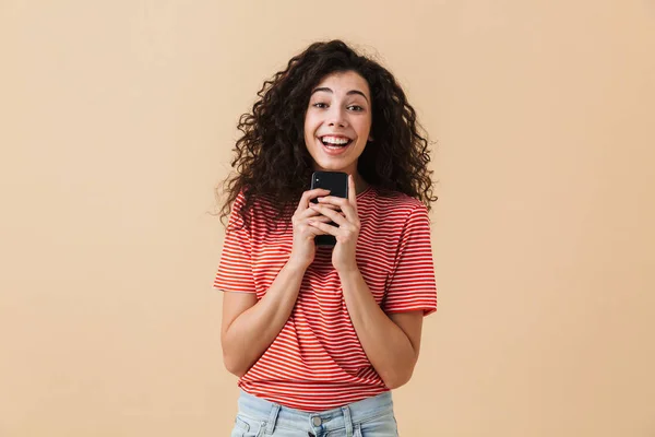 Retrato Uma Jovem Excitada Com Cabelo Encaracolado Segurando Telefone Celular — Fotografia de Stock