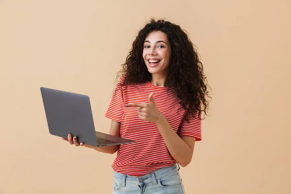 Immagine Eccitata Giovane Donna Riccia Isolata Sfondo Beige Con Computer — Foto Stock