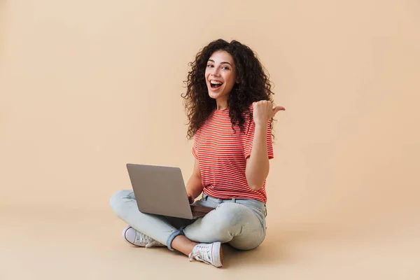 Immagine Graziosa Giovane Donna Riccia Isolata Sfondo Beige Utilizzando Computer — Foto Stock