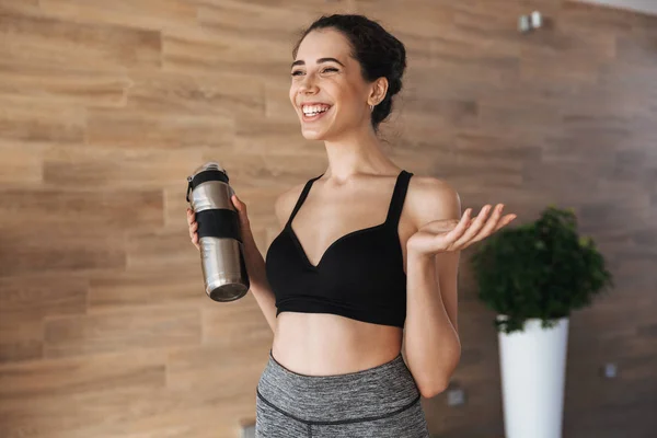 Joven Deportista Sonriente Sosteniendo Una Botella Agua Mientras Está Pie — Foto de Stock