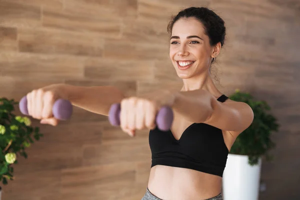 Joven Deportista Satisfecha Haciendo Ejercicio Con Pesas Mientras Está Pie —  Fotos de Stock