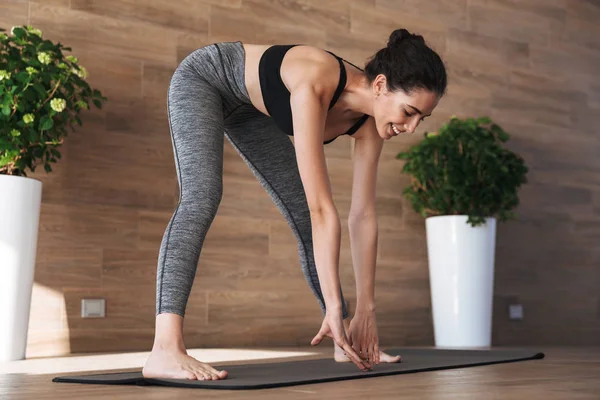 Spor salonunda germe egzersizleri yapıyor gülümseyen genç sporcumuz portresi