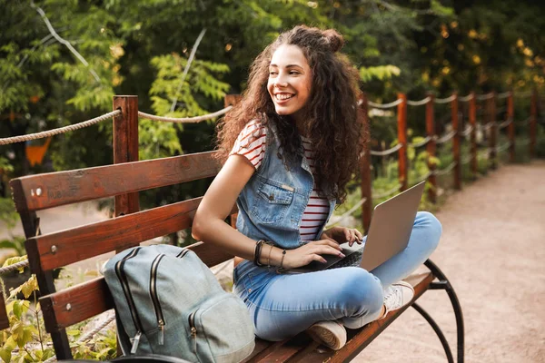 Photo Pretty Young Woman 20S Curly Hair Sitting Bench Green — Stock Photo, Image