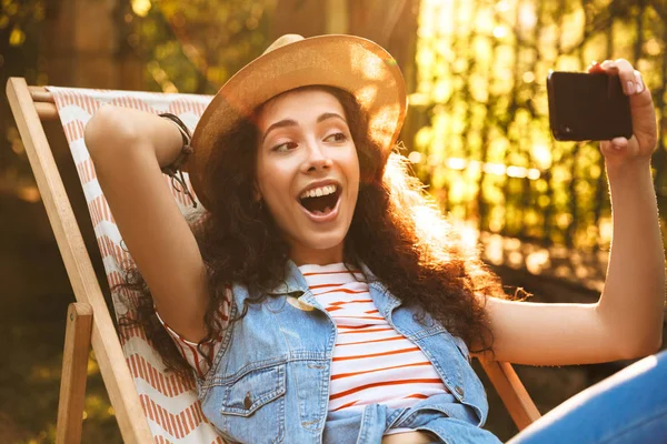 Açık havada park yapmak selfie cep telefonuyla konuşan genç güzel bir kıvırcık kadın görüntüsünü.