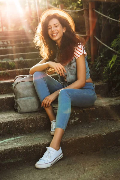 Şirin mutlu genç güzel kadın park açık havada adımda oturan görüntüsü. Görünümlü kamera.