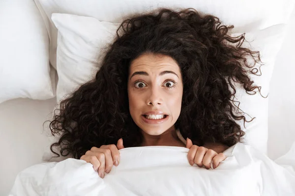 Eğlenceli Sinirli Kadın Siyah Kıvırcık Saçlı Beyaz Battaniye Altında Yatakta — Stok fotoğraf