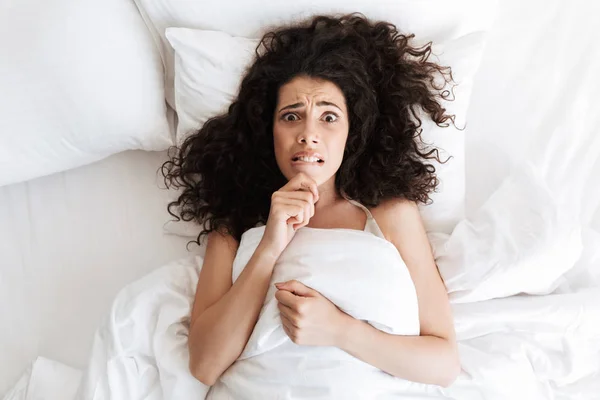 Photo Confused Young Woman 20S Dark Curly Hair Touching Chin — Stock Photo, Image