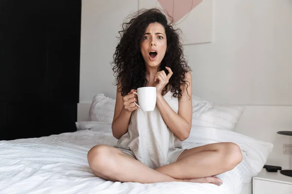 Portrait Emotional Curly Woman Open Mouth Sitting Bed White Clean — Stock Photo, Image