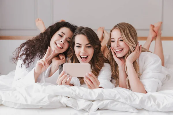 Tres Hermosas Mujeres Años Con Albornoz Blanco Acostadas Dormitorio Lujo —  Fotos de Stock