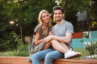 Birlikte tezgah açık havada üzerinde otururken kameraya bakarak mutlu güzel çift