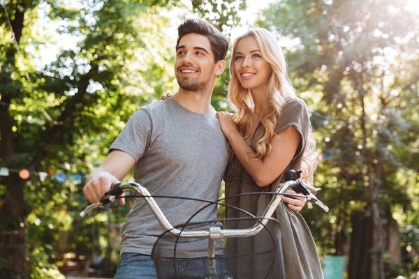幸福可爱的年轻夫妇站在一起骑自行车和看户外的图片 — 图库照片