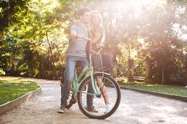 全长图像的快乐可爱的年轻夫妇摆在一起与自行车和看着远离户外 — 图库照片