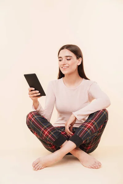Feliz Joven Morena Vestida Pijama Leyendo Ebook Mientras Está Sentada — Foto de Stock
