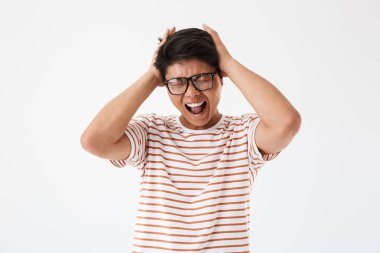 Güneş gözlüğü gözlerle çığlık rahatsız bir genç Asyalı adam portresi üzerinde beyaz izole kapalı