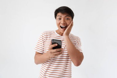 Cep telefonu beyaz arka plan üzerinde izole tutan heyecanlı bir Asya adam portresi