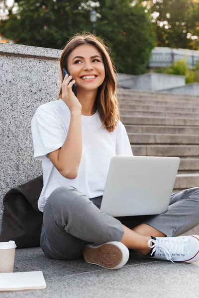 Smiling Young Girl Making Talking Mobile Phone While Sitting Outdoors — Stock Photo, Image