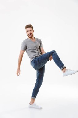 Heyecanlı genç adam beyaz duvar arka plan üzerinde izole ayakta görüntüsünü.