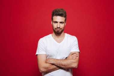 Beyaz t-shirt görünümlü kamera kollu yakışıklı genç görüntü izole kırmızı arka plan üzerinde çarpı işareti.