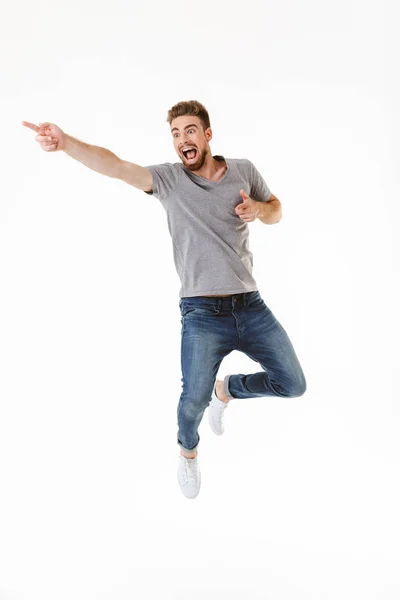 Foto Joven Emocionado Saltando Aislado Sobre Fondo Blanco Pared Apuntando — Foto de Stock