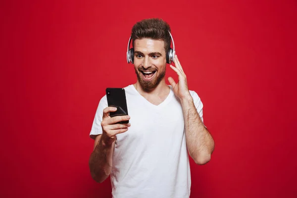 Beyaz Tişört Cep Telefonuyla Kırmızı Arka Plan Üzerinde Izole Kulaklık — Stok fotoğraf